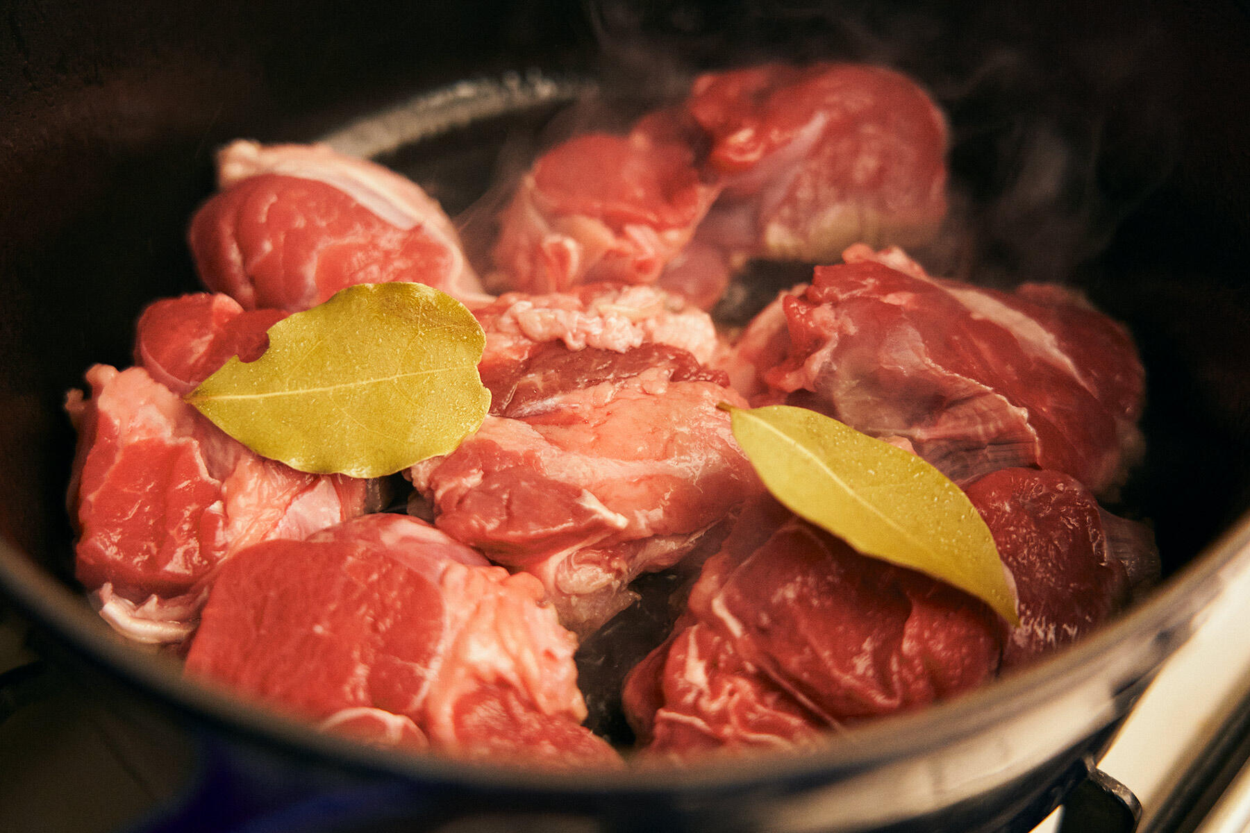 鍋に肉を入れる