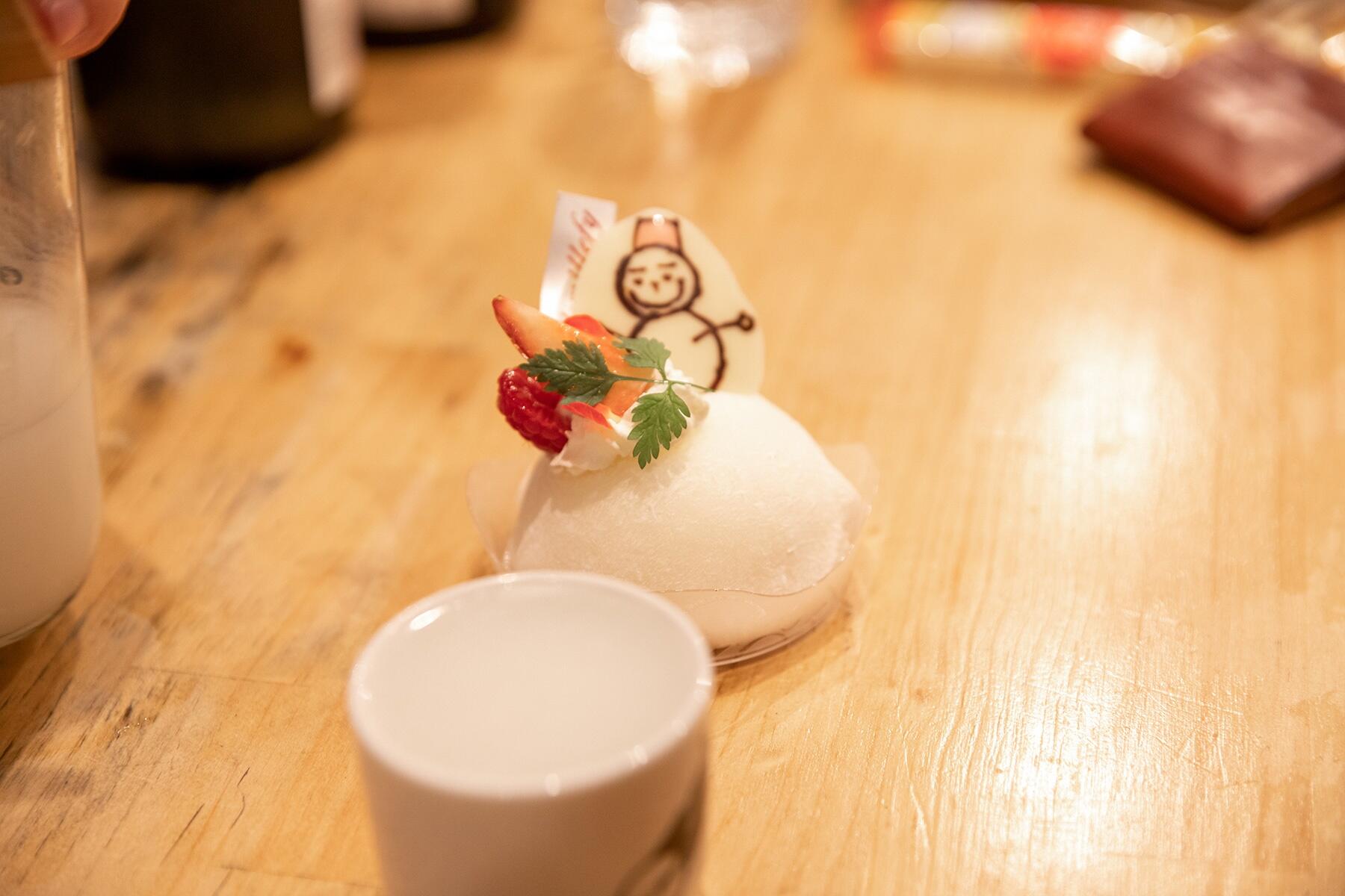 お猪口に入った酒とケーキ