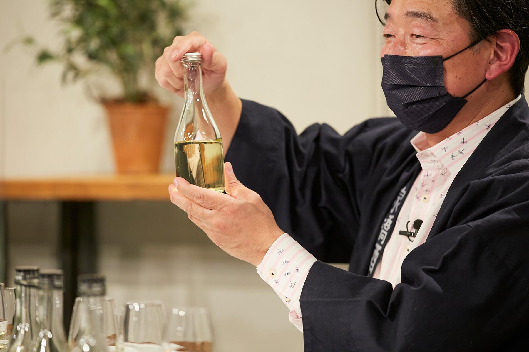 瓶を持つ橋場友一さん