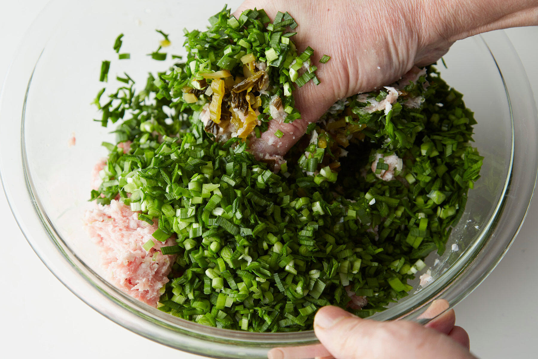 にらと高菜漬を加え、さらに混ぜる