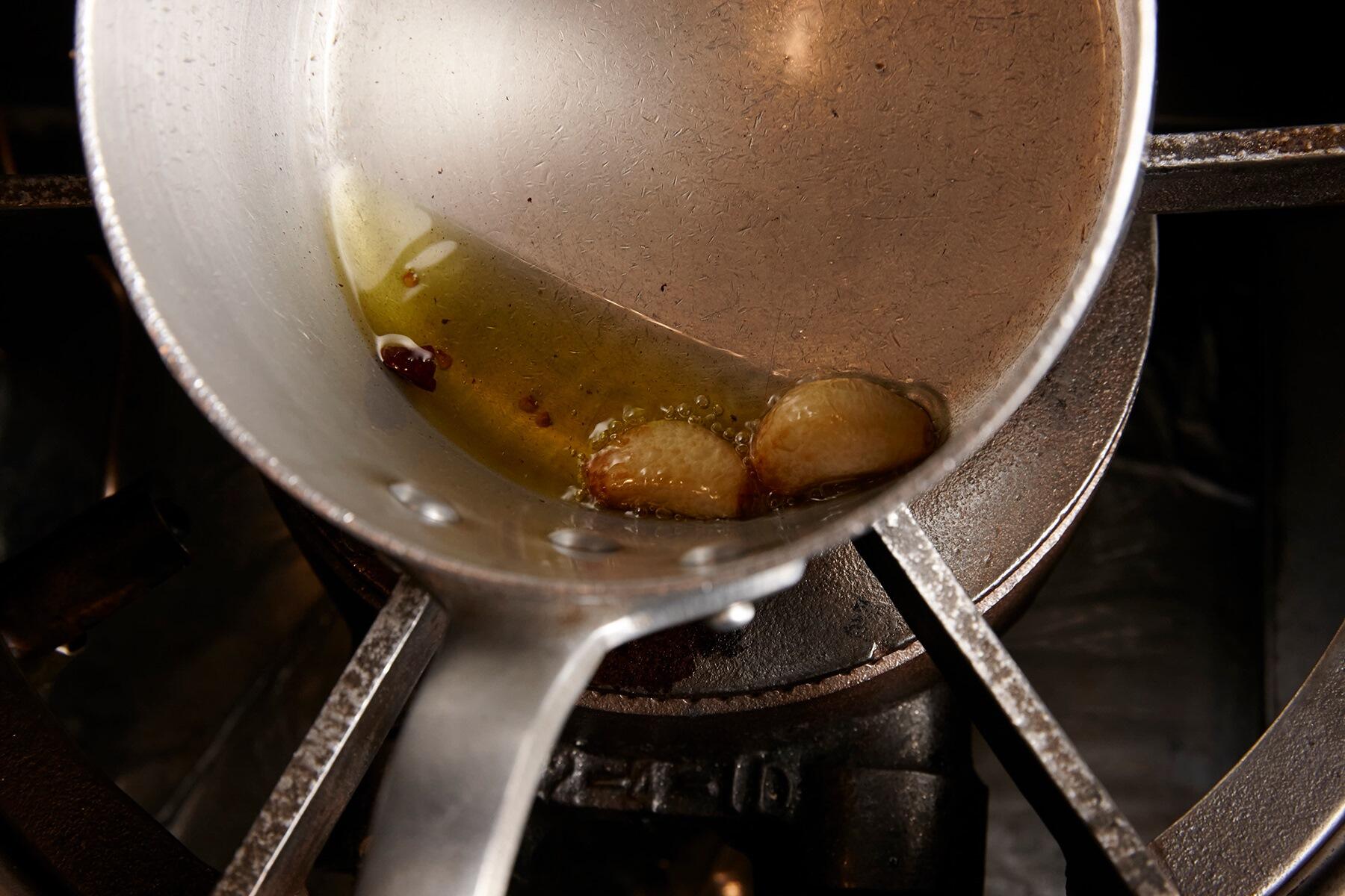 にんにくと唐辛子を火にかける