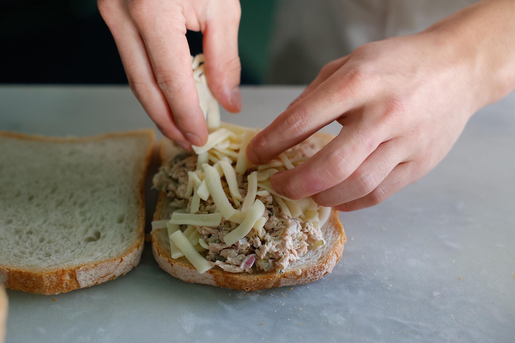 パンにチーズとツナソースをはさむ