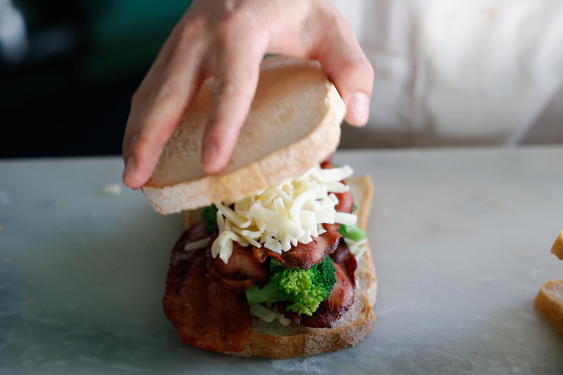 パンにチーズと具材をはさむ