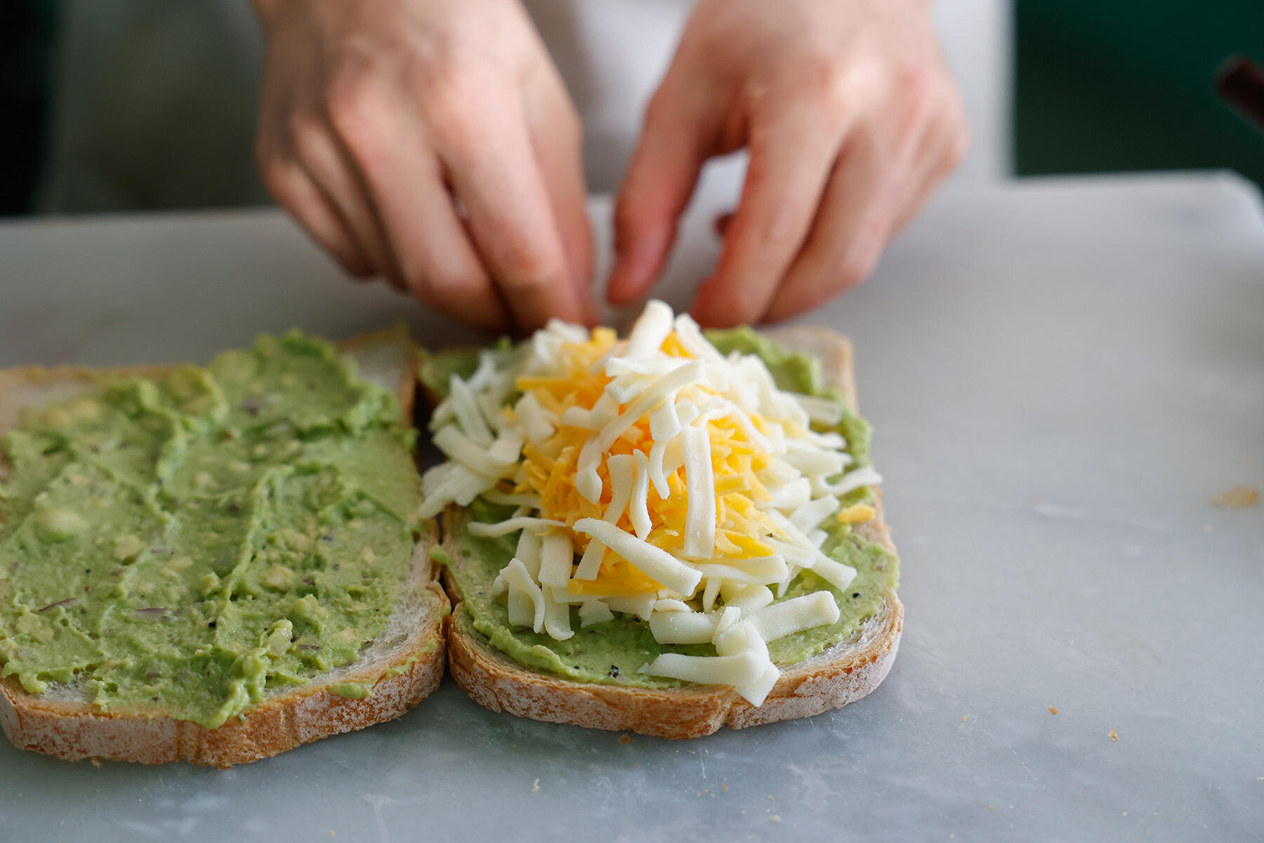 パンにワカモレを塗り、チーズをはさむ