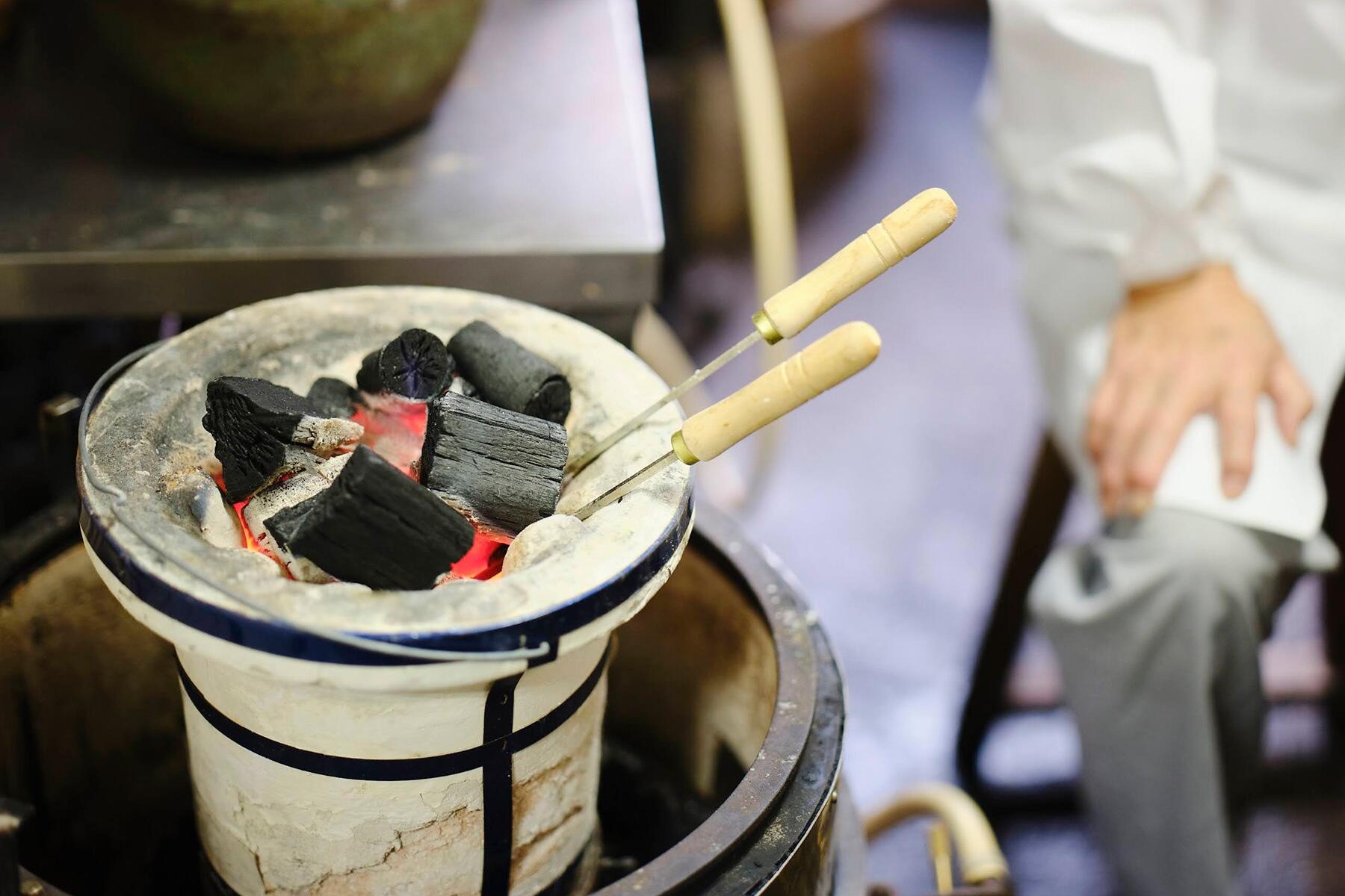 七輪の炭火に入ったコテ