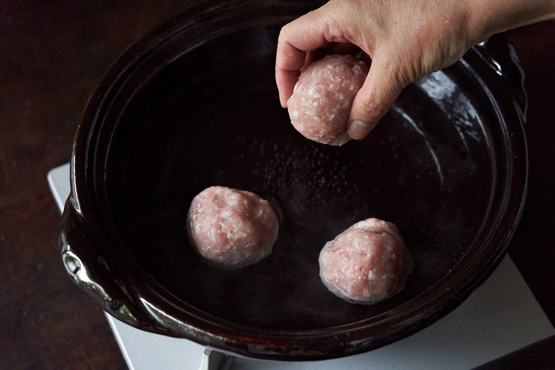 土鍋に鶏だんごを入れる