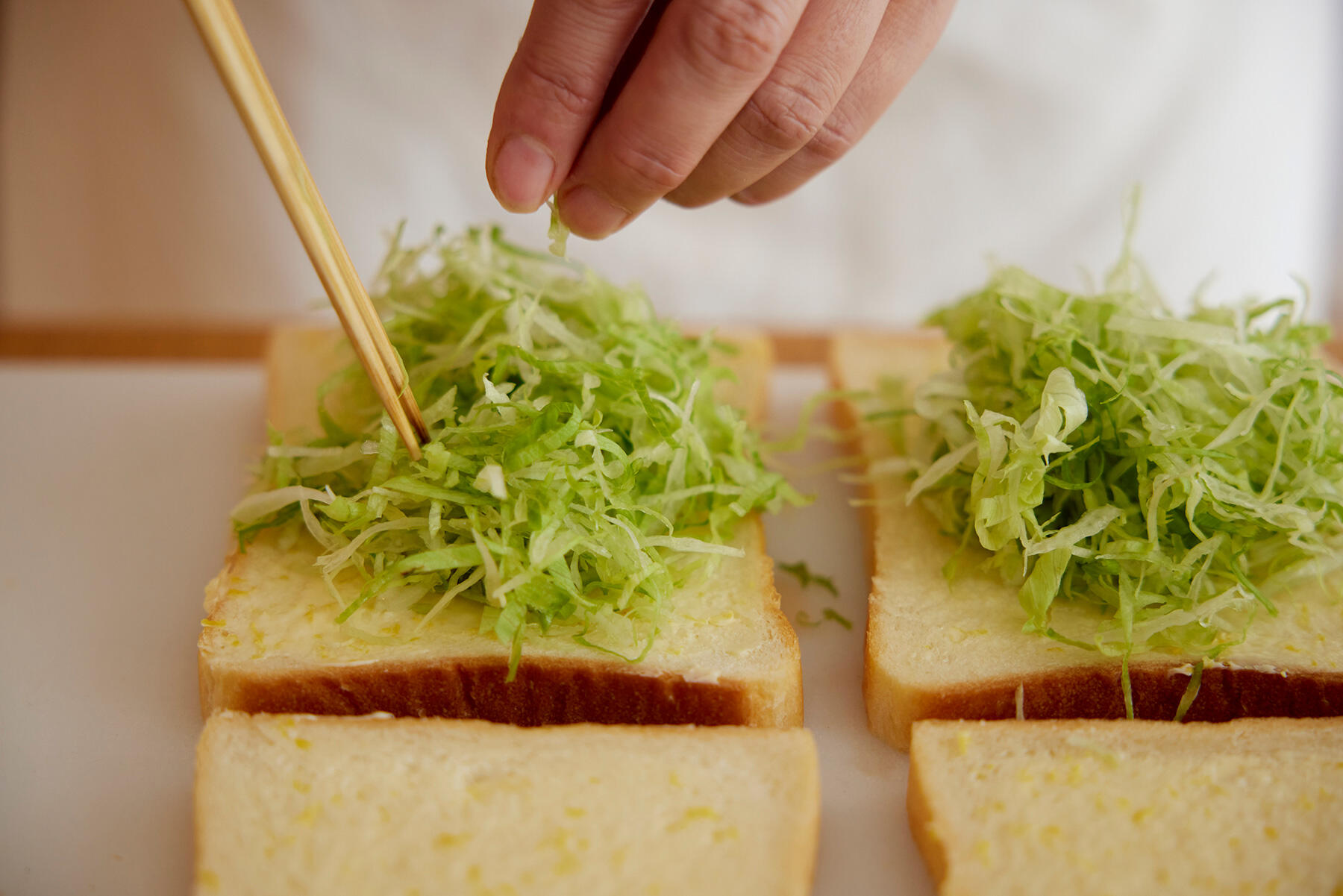 レタスをパンにのせる