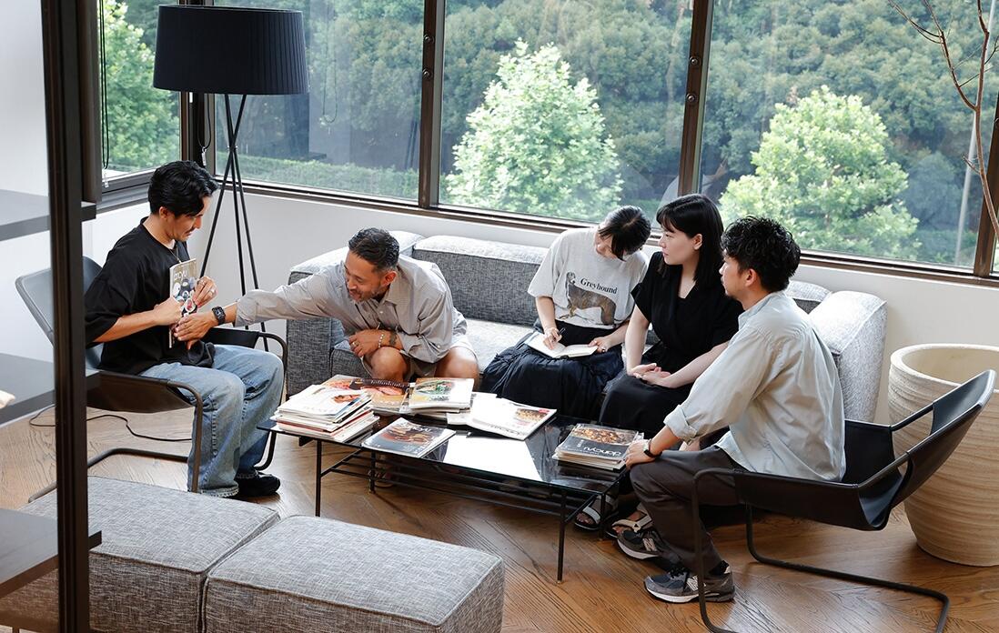 雑誌を服に当ててみるメンバー