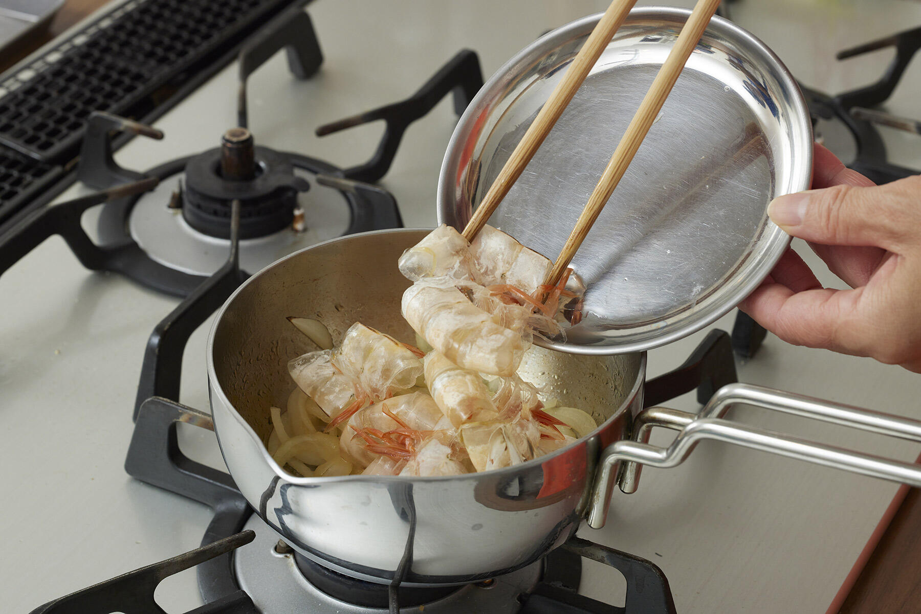 玉ねぎと海老の殻を炒める
