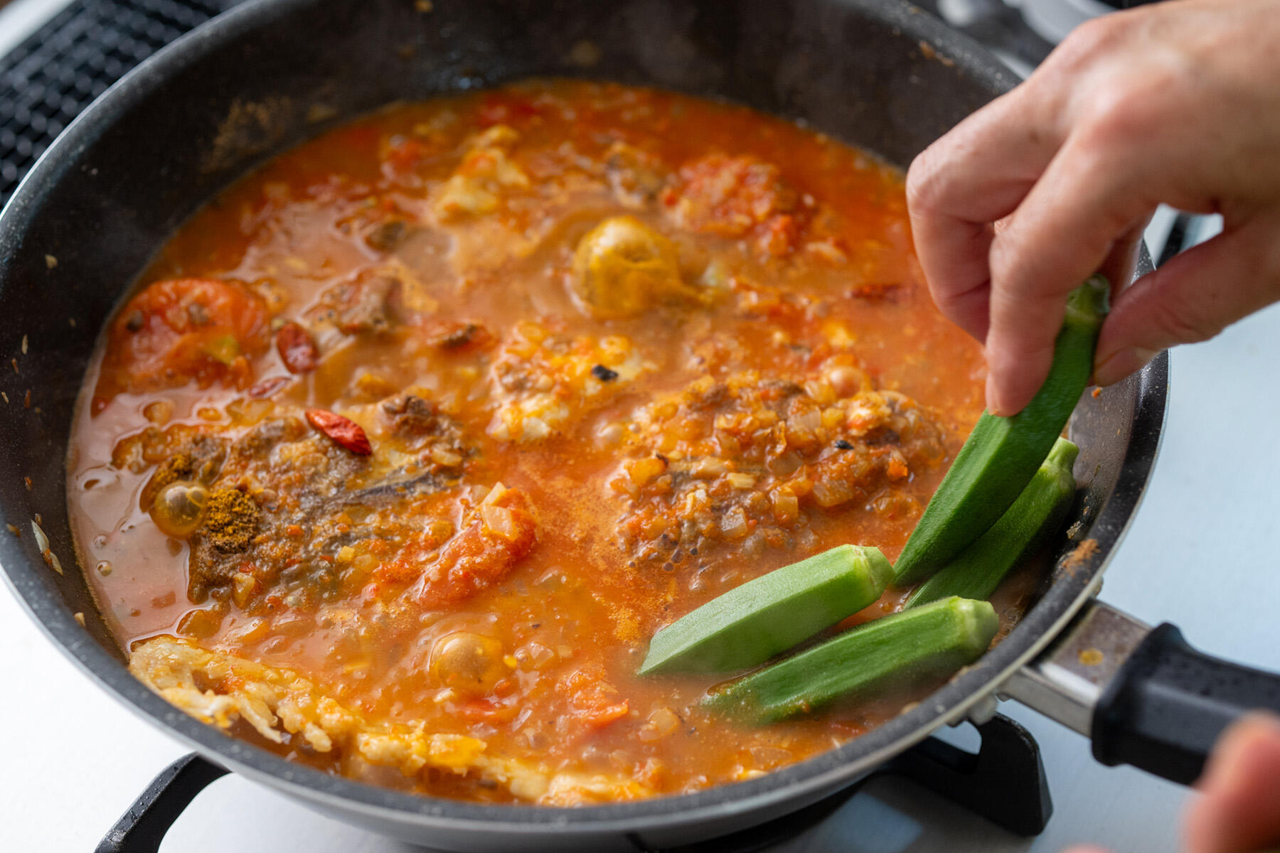 スパイスとオクラを加えて煮こむ