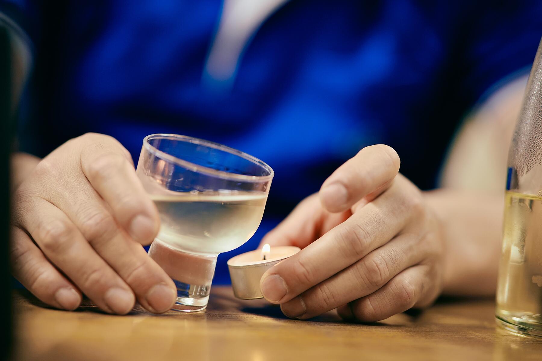 グラスの熟成酒をろうそくの炎で温める