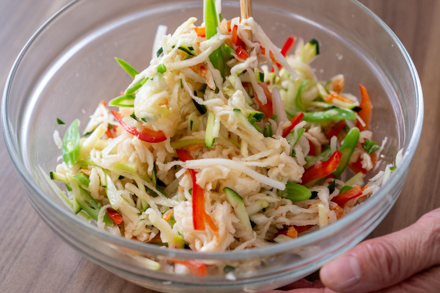 保存がきくからと、買いおきしがちな“切り干し大根”。油断していたらとっくに賞味期限切れ、しかも変色してした……というのは、乾物あるある。しかも、煮物以外になかなかレシピが思い浮かばず、使い切るのが難しいと感じている人も多いはず。尾身さんは切り干し大根、いつもどうやって食べてますか? 「うちでは意外と、煮物以外の料理にすることが多いんです。よくつくるのは、ハリハリ漬け。炒め物にしてもおいしいんですよ。和食のイメージが強いと思うんですが、今回はエスニック料理に使います!」 そう話しながらつくってくれたのは、なんとタイ料理では定番の“ソムタム”。本来は青パパイヤのせん切りを使うサラダで、ナンプラーや唐辛子をきかせた甘酸っぱいタレで和える。尾身さんは、なかなか手に入れにくい青パパイヤのかわりに、切り干し大根を使うというわけなのだ。 「シャキッとした食感がソムタムにぴったりなんです。しかも、切り干し大根は水でもどすだけ。青パパイヤを切る手間いらずで、おいしく食べられるんですよ」 確かに、切り干し大根は水でもどせば火を通さなくても食べられるので、災害の備蓄にも適しているといわれる。実は手間まで省けてしまう、便利な食材なのだ。