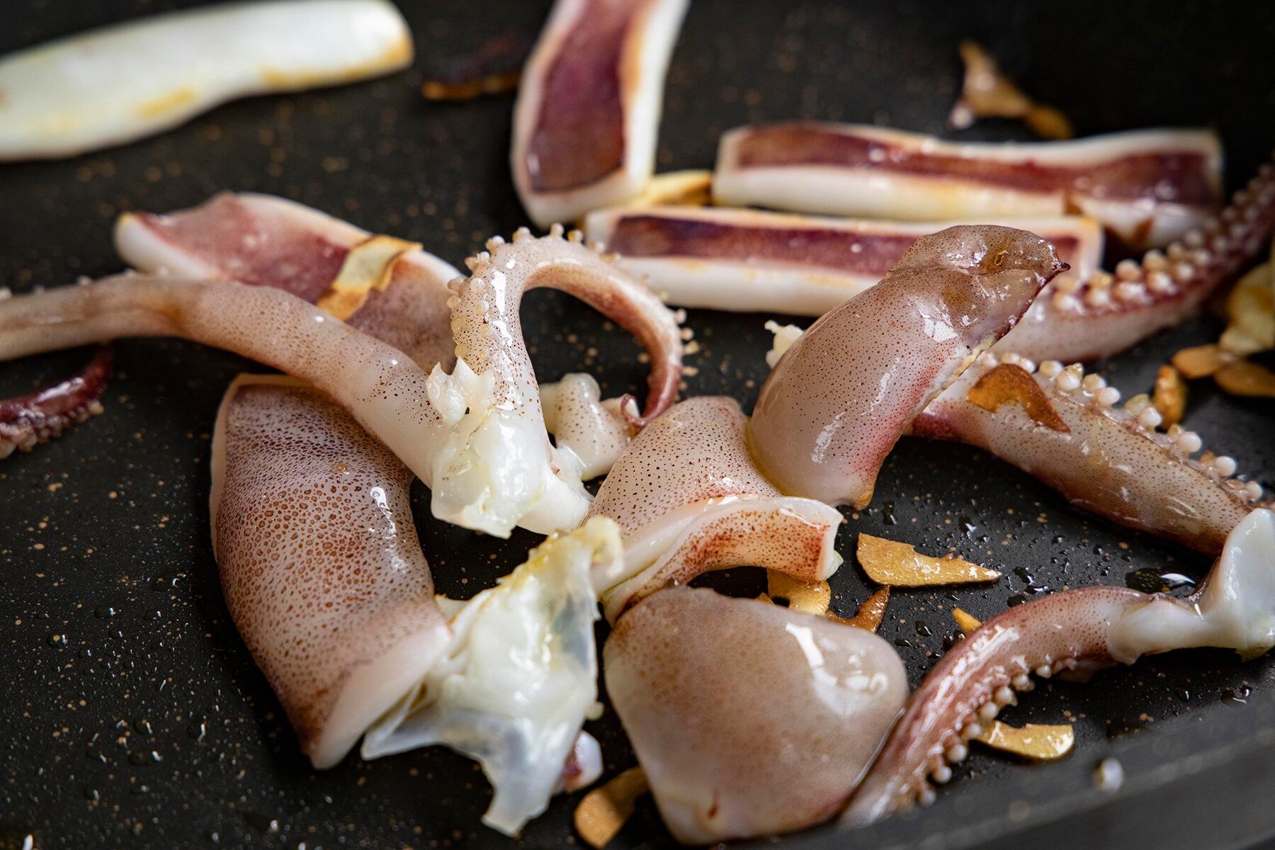 オリーブオイルとにんにくを熱したフライパンに投入する