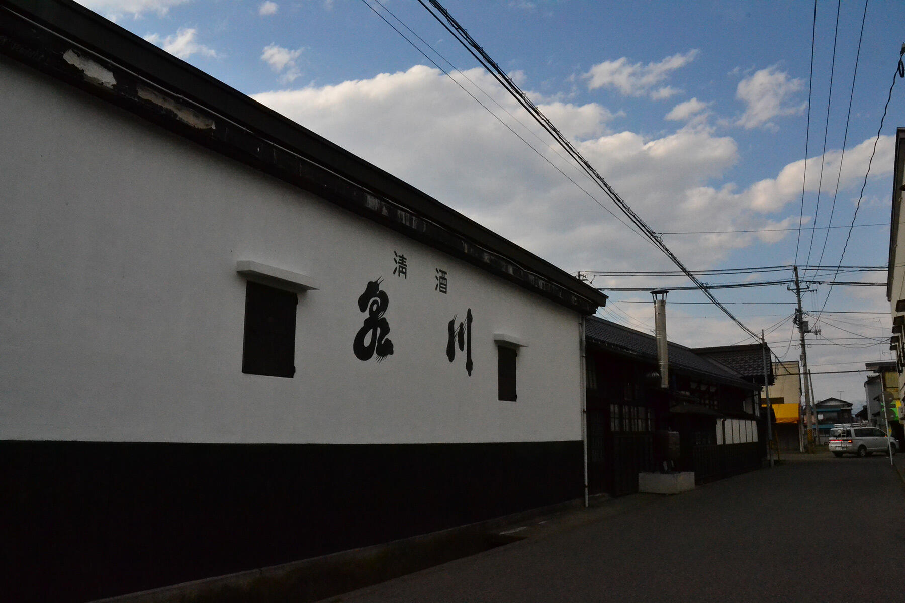 酒蔵の白壁には、代々の銘柄「泉川」が記されている(2015年4月撮影)。