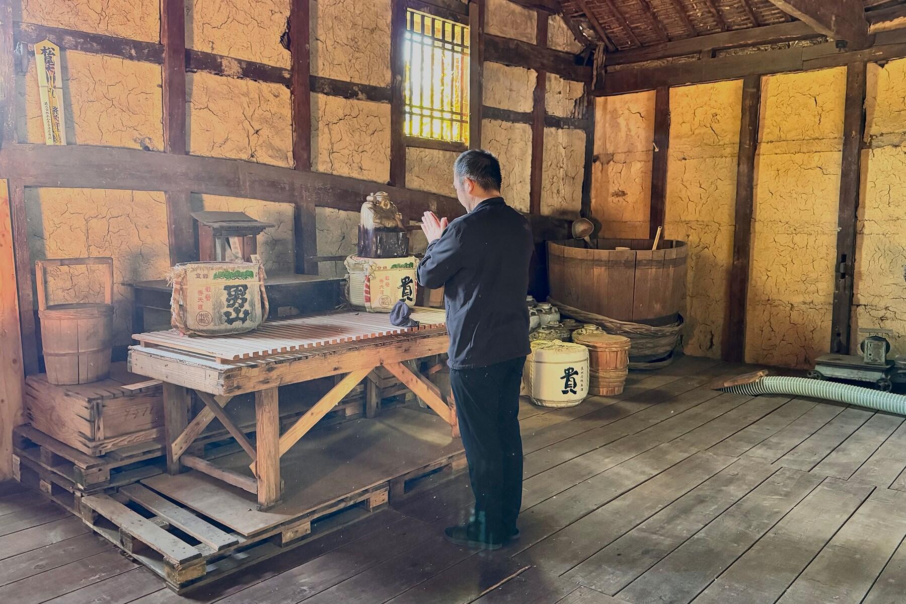 米を神棚に供える永山さん