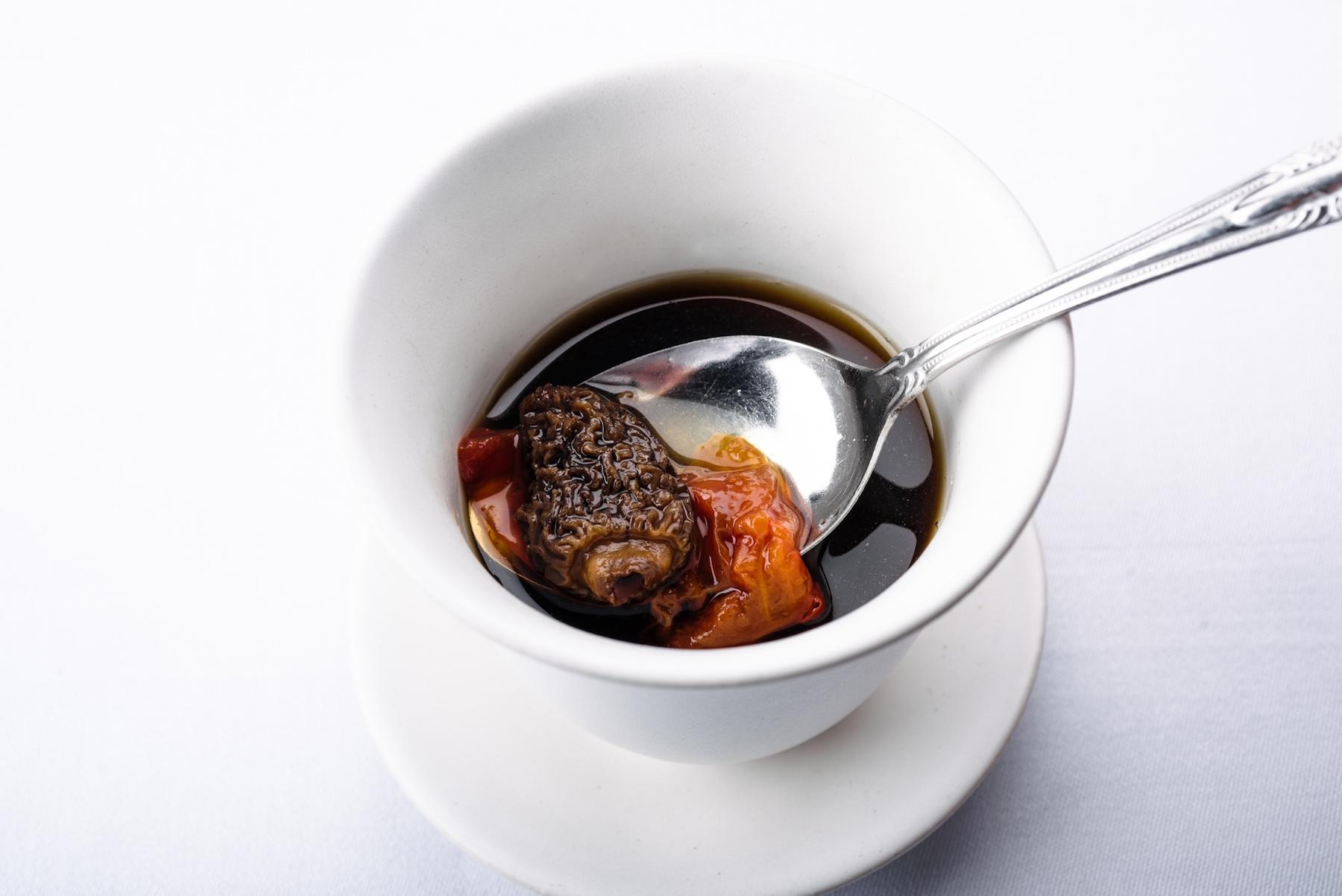 スプーンですくうと、立派なアミガサ茸が。煮込んだとろとろのトマトから出る酸味とのバランスの妙。猟師の渡辺さん宅の裏庭からは、ゆずの皮を一片。