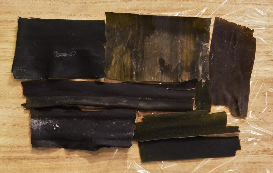 ①ラップフィルムの上に、鶏肉の大きさに合わせて昆布をパズルのように並べる。