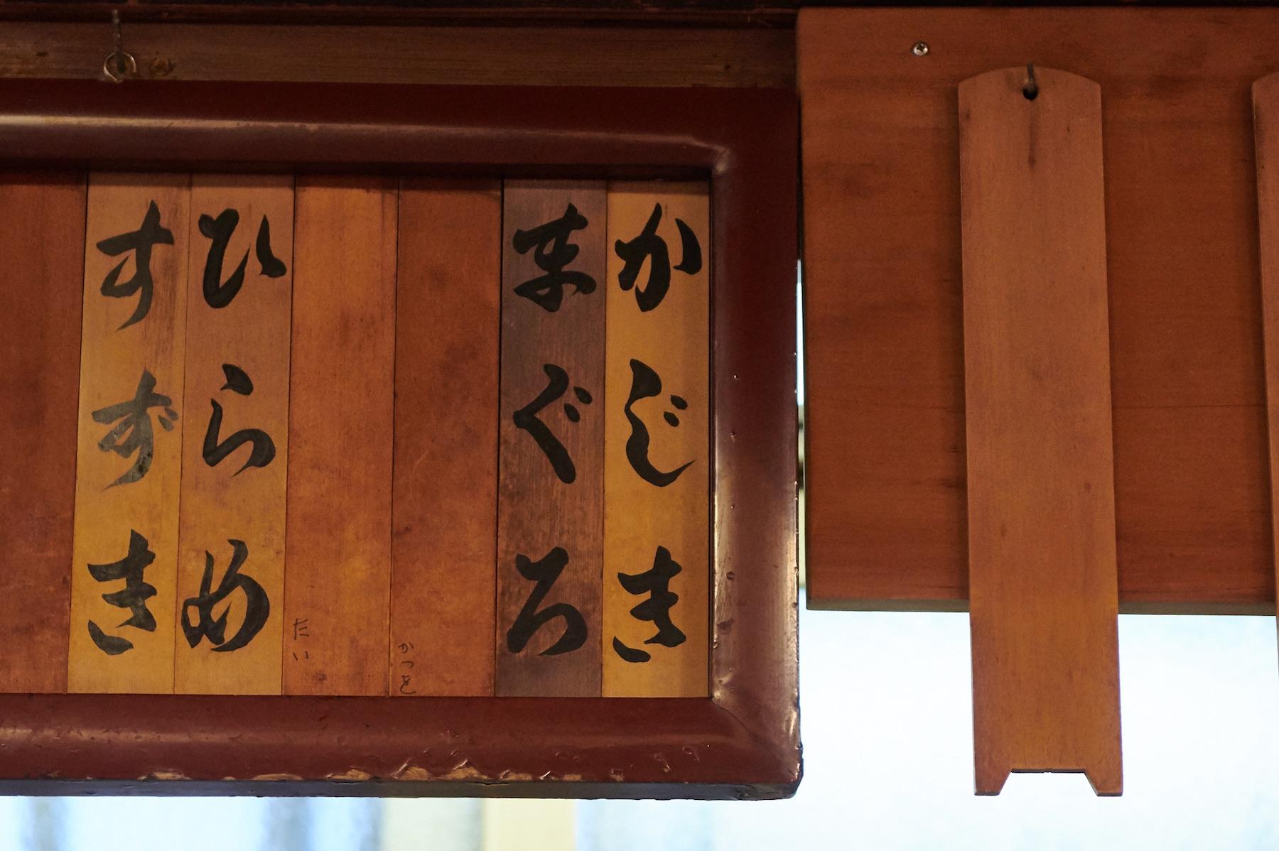 冬。「㐂寿司」の品書きの右側にはカジキとマグロが並ぶ。