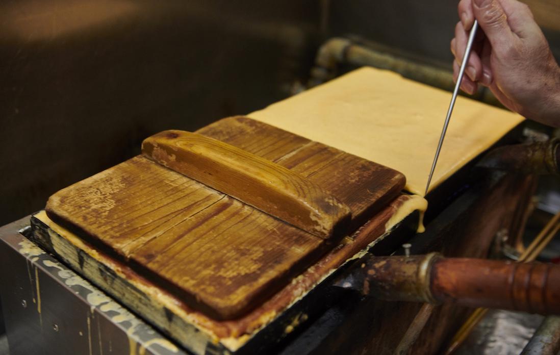 金串を打ち、木蓋で圧をかけて空気を抜いて、握りのための玉子焼きに仕上げていく。
