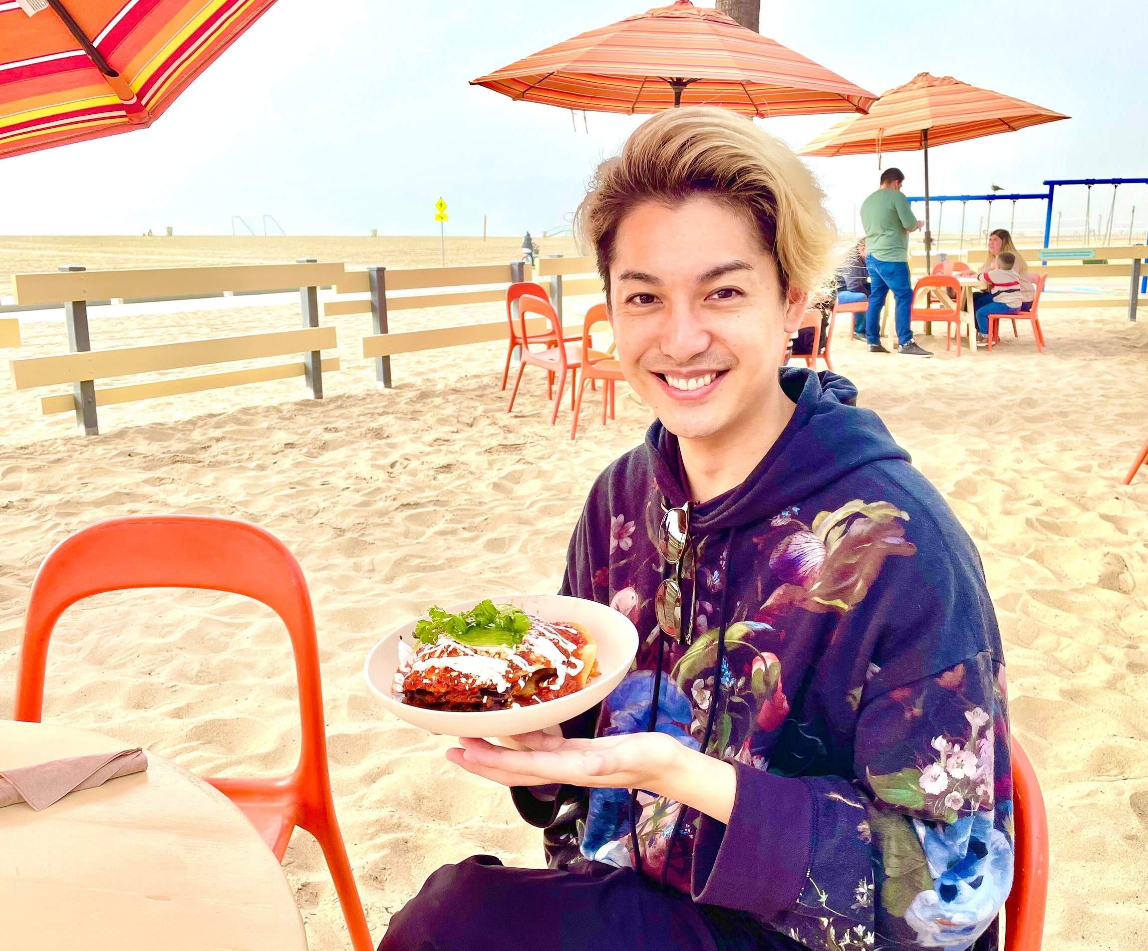 ビーチでプレートを持つ大野さん