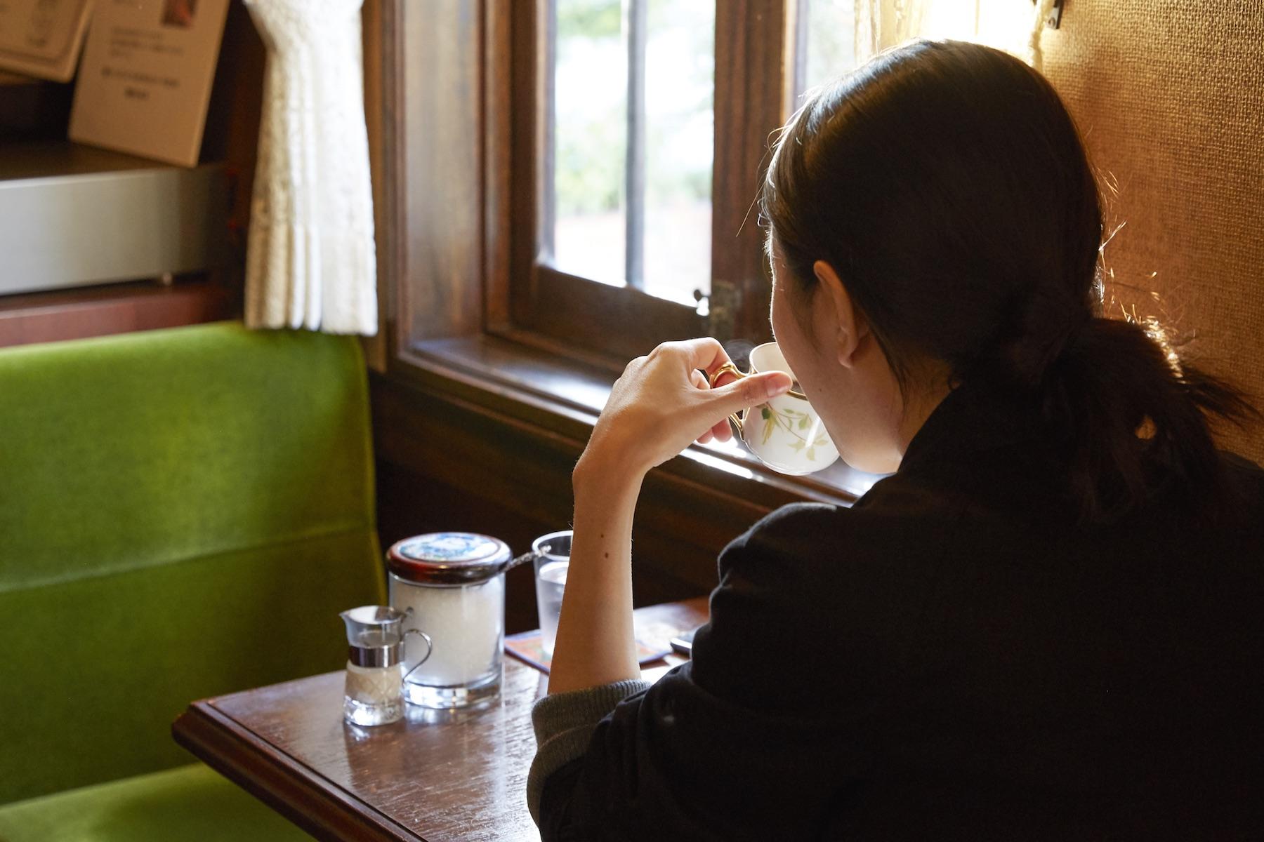 陽射しが射し込む小さめのテーブル席で寛ぐ女性。一杯の珈琲を静かに味わいながら、自分と向き合い、対話している人の姿はとても美しく、見ているこちらまで豊かな気持ちにさせてくれる。「蘭館」には1人客も多い。