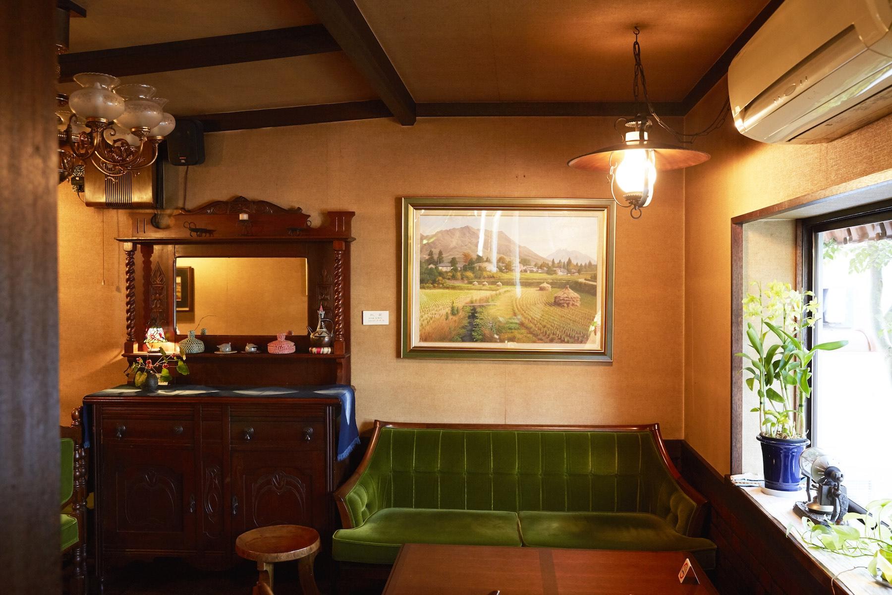 カウンター奥に進むと、贅を尽くした喫茶空間が広がっている。ベルベット生地が心地いいソファ、今ではめずらしい低めのティーテーブルを配した空間は、もともとは蘭の栽培に使っていた温室だったとか。