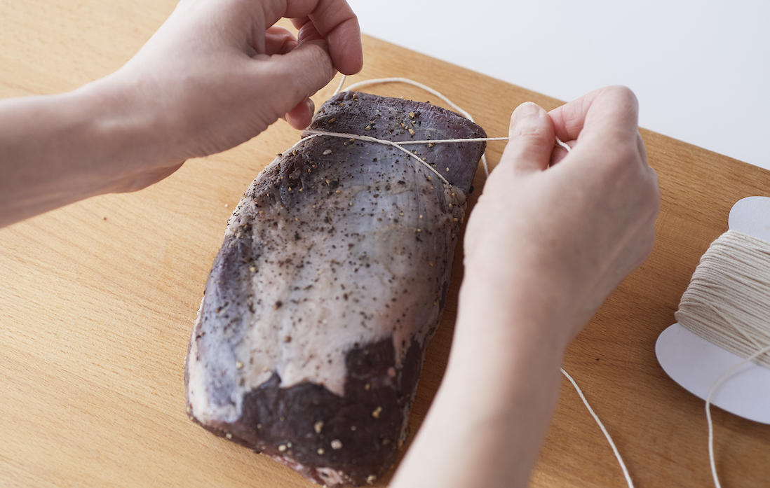 1、牛肉を縦向きに置いて、奥側から1.5cmほどのところから縛り始める。